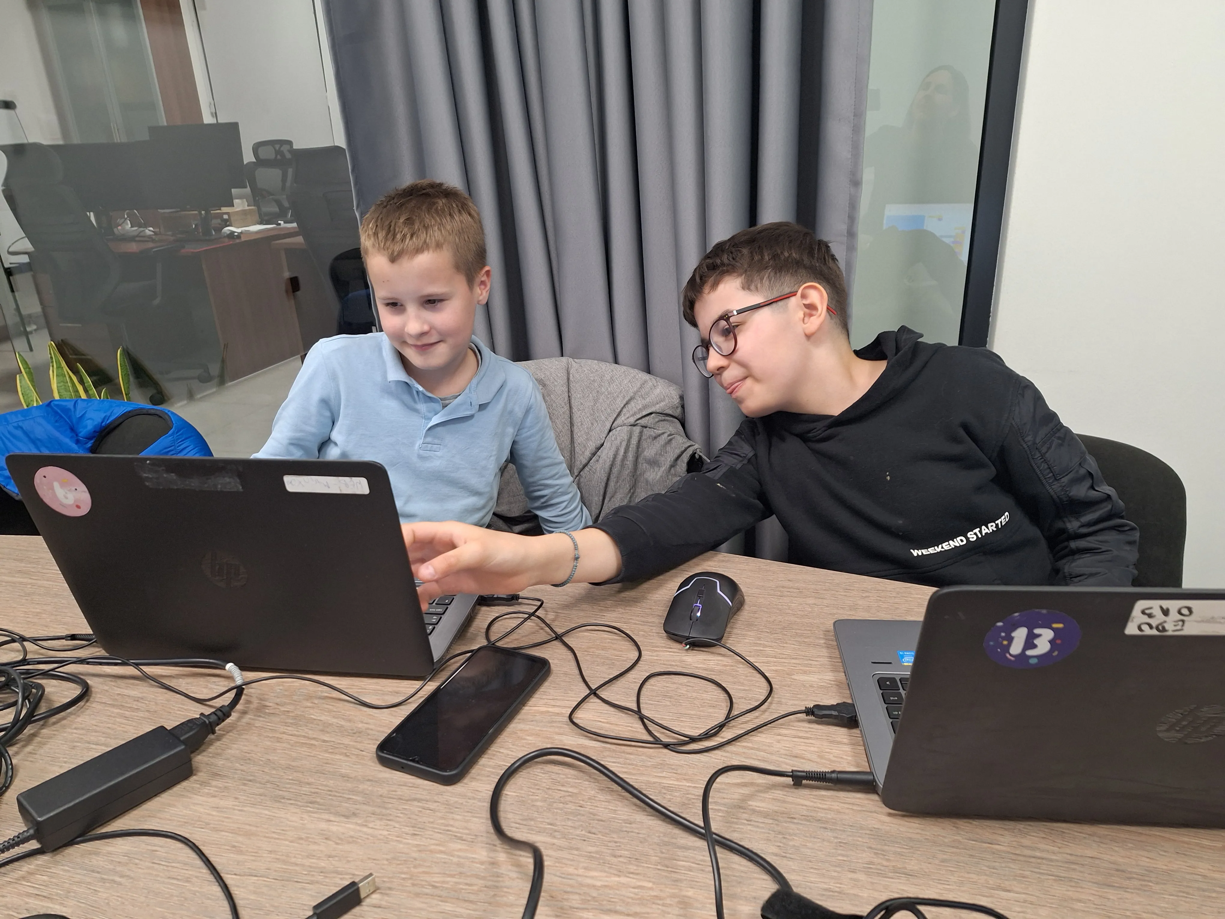 Djeca i predavač zajedno rješavaju izazove u kodu